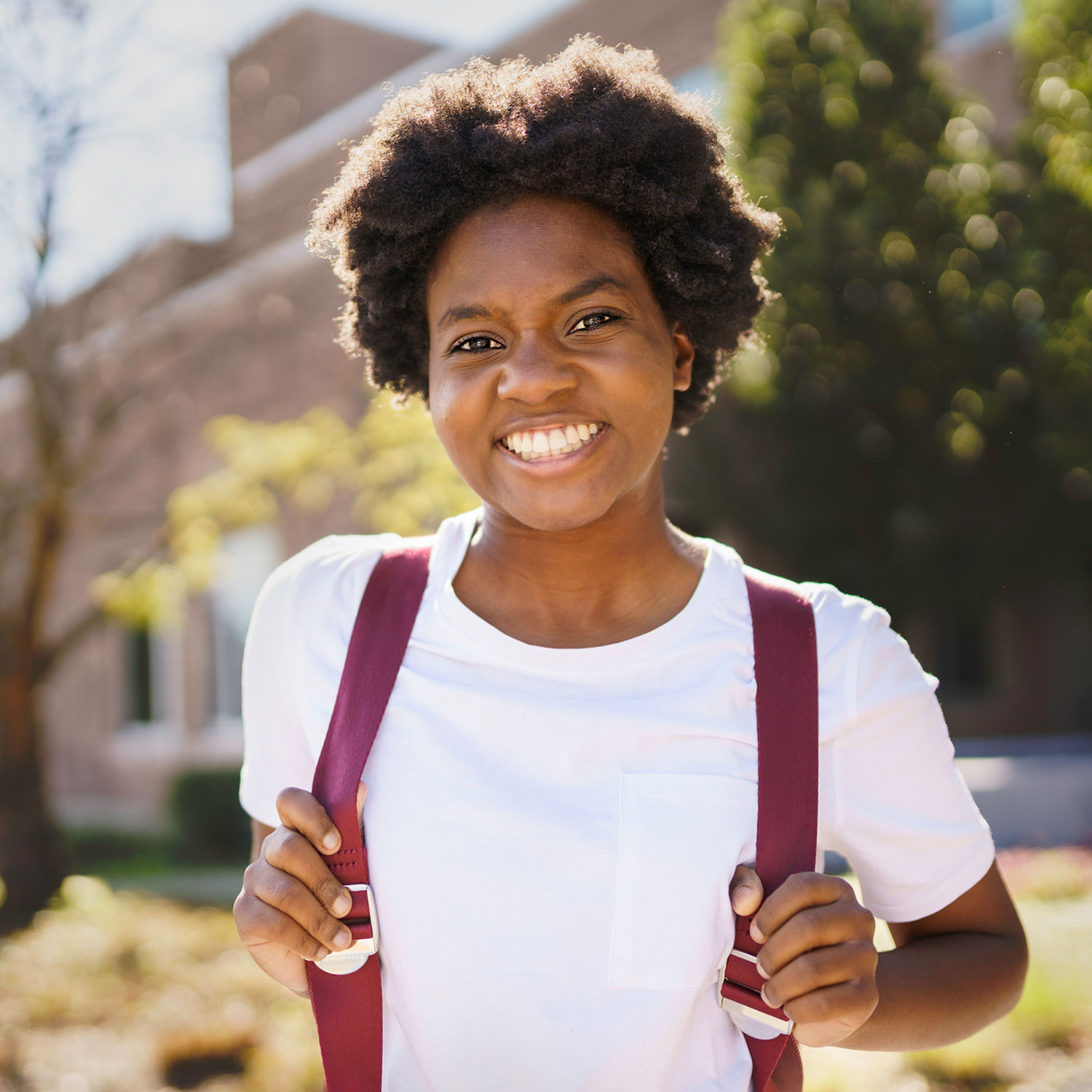 Teen girl wearing backpack and smiling