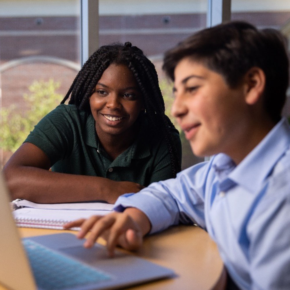 Student and mentor working at a laptop