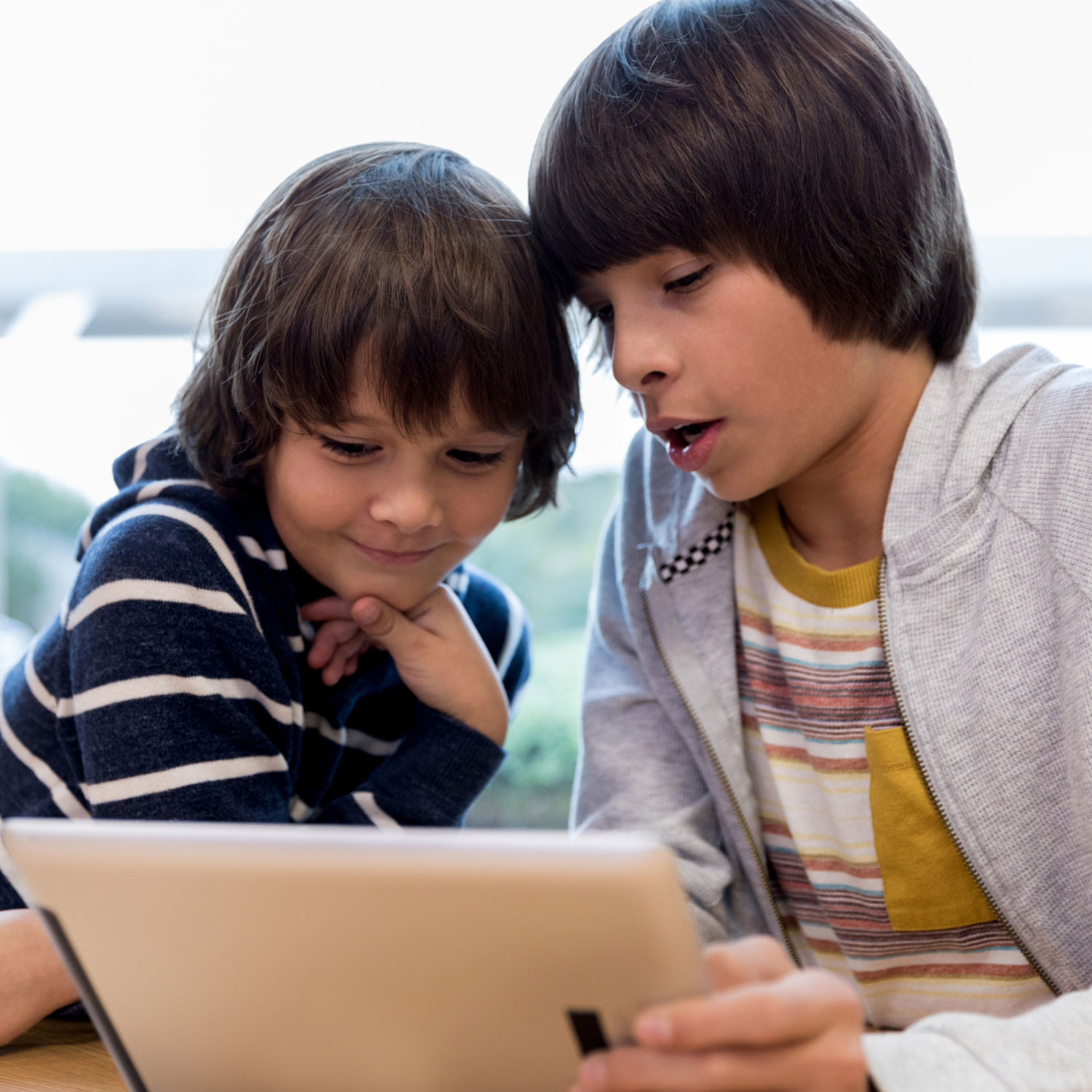 Two boys using a tablet device.
