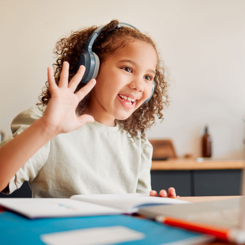 Student wears headphones and interacts with online class.