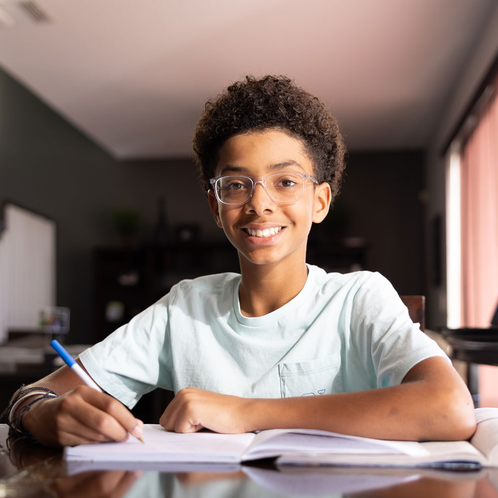 Student wearing glasses works on homework.